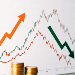 금화 더미 앞에 주가 상승을 나타내는 주황색 화살표와 하락을 나타내는 녹색 화살표가 대비되어 표시된 금융 시장 변동성 차트